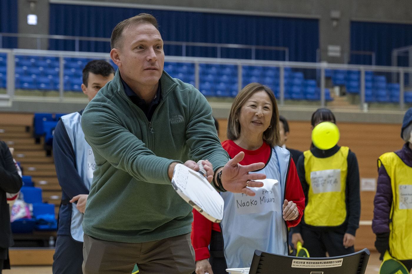 A coach demonstrates a toss during a beginner pickleball clinic